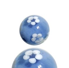 two blue and white marbles with flowers on them