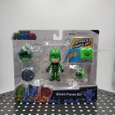 the green lantern figure is on display in front of a black and white polka dot background