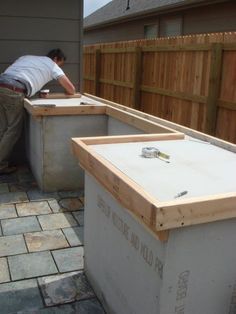 a man working on an outdoor kitchen in the back yard with bricks and pavers