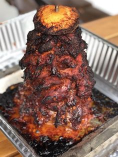 a large piece of meat sitting on top of a metal pan covered in burnt food