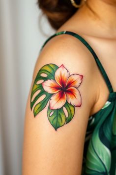 a woman's arm with a flower tattoo on the left side of her shoulder