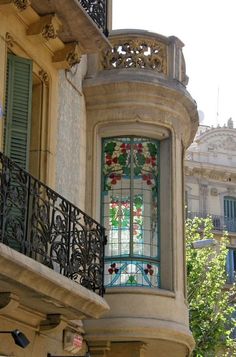 an ornate balcony with stained glass windows and wrought iron balconies on the second floor