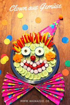 a birthday cake made to look like a clown face with lots of candy on it