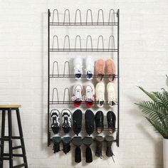 a wall mounted shoe rack with many pairs of shoes hanging on it's sides