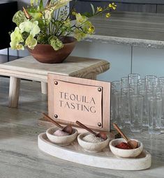 there are three bowls and two spoons on the table next to each other in front of a sign that says tequila tasting