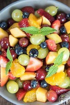 fresh fruit salad with mint garnish in a bowl