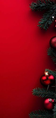 a red christmas tree with ornaments and lights on it's branches against a bright red background