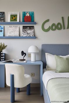 a bedroom with blue and white bedding, two desks and shelves on the wall