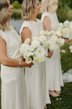 the bridesmaids are holding white flowers in their hands