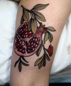 a woman with a tattoo on her leg has a pomegranate