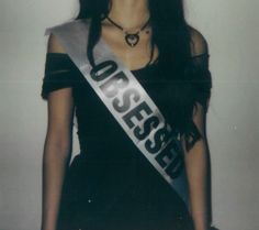 a woman in a black dress with a silver sash