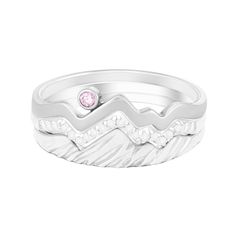 a white gold ring with a pink diamond in the center and waves on it's sides