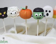 an assortment of halloween cake pops with faces on them