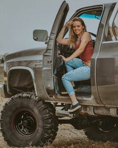 a woman sitting in the drivers seat of a truck