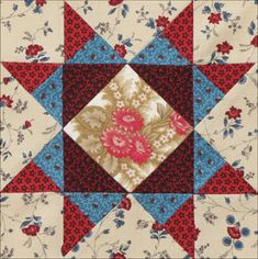 a red, white and blue quilt with flowers on it