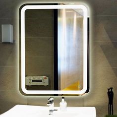 a bathroom sink with a lighted mirror above it