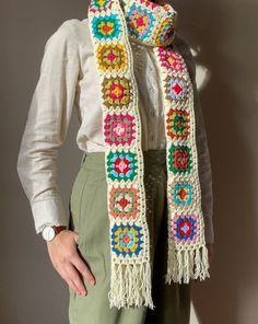 a woman is wearing a crocheted scarf with fringes and beads on it