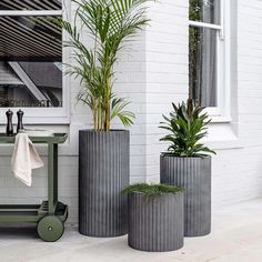 three tall planters sitting next to each other