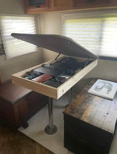 the inside of a camper with an open trunk on it's end table