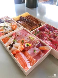 four different types of sushi in trays on a table