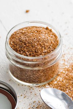 a jar filled with spices next to a spoon