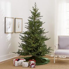 a small christmas tree in the corner of a room with presents on the floor next to it