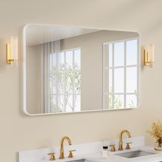 a bathroom sink under a large mirror with gold faucets on the counter top