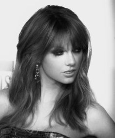 a black and white photo of a woman with long hair wearing a strapless dress