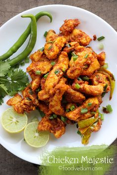 chicken and peppers on a white plate with lime wedges