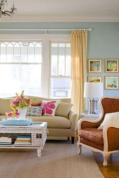 a living room filled with furniture and a chandelier hanging from the ceiling in front of a window