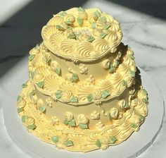 a three tiered cake sitting on top of a white plate next to a marble counter