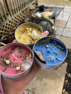 three tins filled with different types of food sitting on top of a patio table