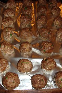 some meatballs are sitting on foil and ready to be cooked in the oven or used as an appetizer