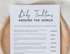 a baby traditions card sitting on top of a wooden plate next to a white napkin