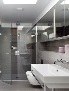 a bathroom with a sink, toilet and shower stall in the middle of it's walls