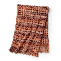 an orange and brown knitted blanket on a white background