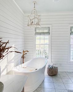 a large white bath tub sitting inside of a bathroom