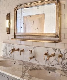 a bathroom vanity with two sinks and a large mirror