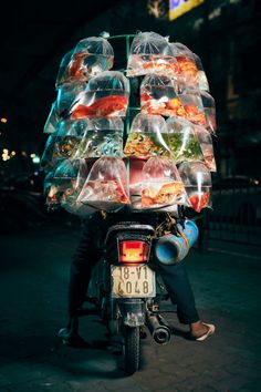 a person on a motorcycle with food in plastic bags strapped to it's back