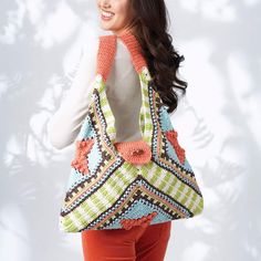 a woman carrying a multicolored crocheted purse