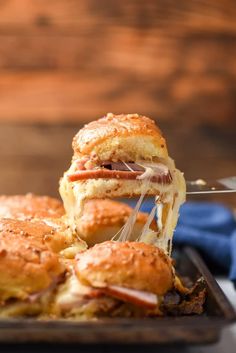 ham and swiss sliders on a tray with text overlay that reads hawaiian ham and swiss sliders