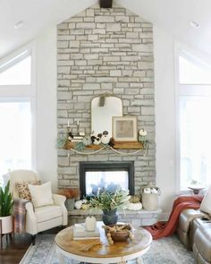 a living room filled with furniture and a fire place in front of a brick wall