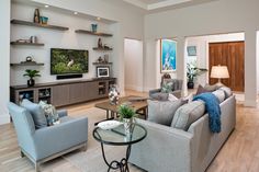 a living room filled with furniture and a flat screen tv mounted on the wall above it