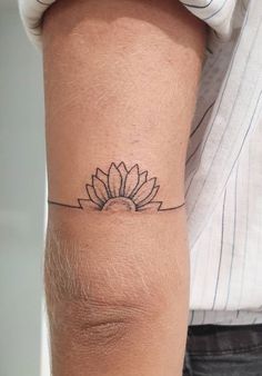 a man's arm with a tattoo on it that has a sunflower in the center