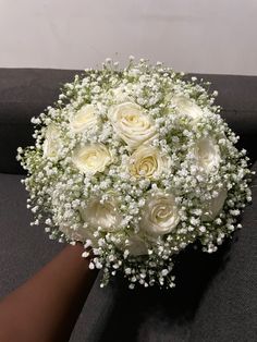 a bridal bouquet with white roses and baby's breath