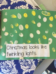 a green and yellow christmas book with white writing on the front cover that says christmas looks like twirling lights