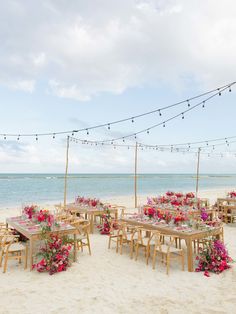 tables and chairs set up on the beach for an outdoor wedding reception with string lights