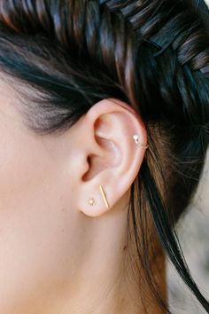 a close up of a woman's ear with two piercings on the side