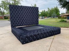 a black bed sitting in the middle of a driveway