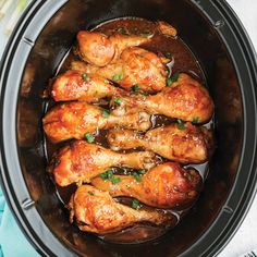 chicken legs in a slow cooker with brown sauce and parsley on the side